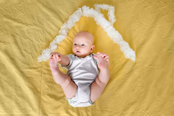Top view of infant child under house roof made of cotton in bed — Stock Photo
