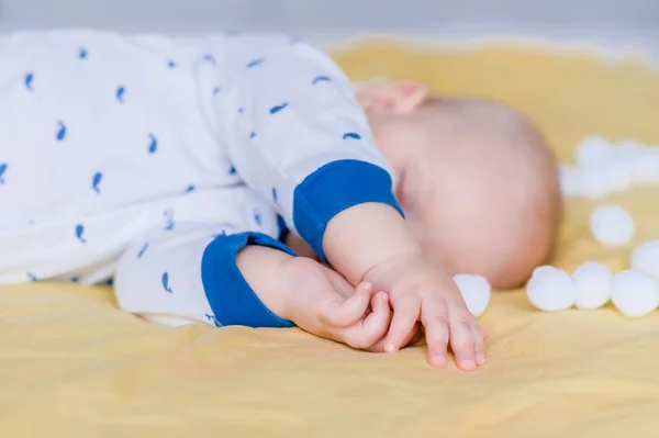 Крупный план младенца, спящего в постели в окружении ватных шариков — стоковое фото