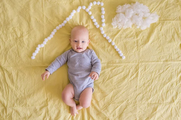 Vista dall'alto dell'adorabile bambino sotto il tetto della casa fatto di batuffoli di cotone e nuvola di cotone sul letto — Foto stock