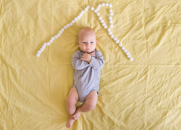 Hermoso niño bajo techo de casa hecho de bolas de algodón en la cama - foto de stock