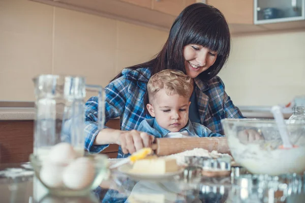 Mutter und Sohn rollen Teig mit Nudelholz — Stockfoto