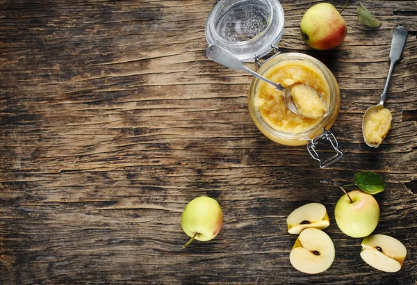 Apple sauce in jars on wooden rustic background, top view, copy