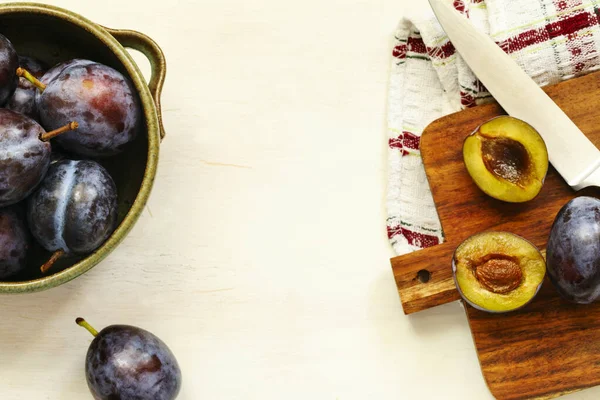 Verse pruimen in schaal op houten tafel, bovenaanzicht — Stockfoto