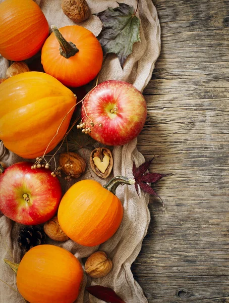 Podzimní dýně a jablka s podzimním listím na dřevěném pozadí — Stock fotografie
