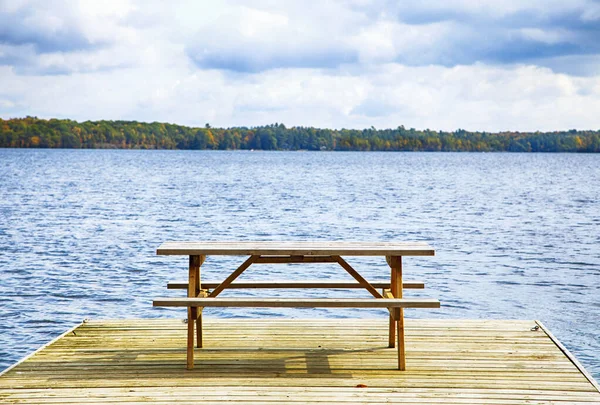 Empty footbridge with a bench on a lake — Stock Photo, Image