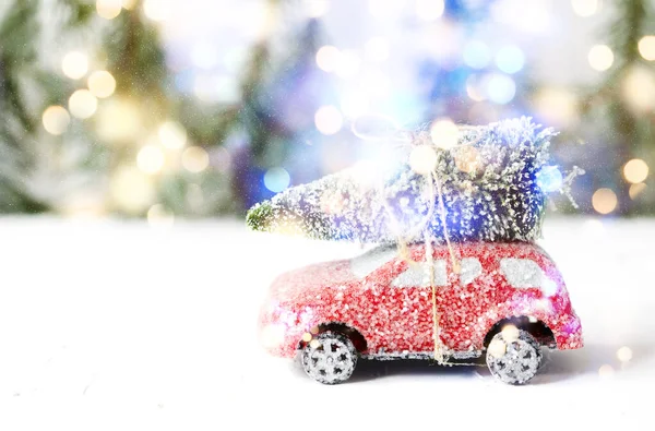 Різдвяна ялинка на іграшці червоного автомобіля зі снігом. Зимові свята святкують — стокове фото