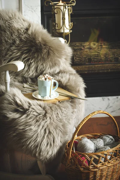 Чашка горячего шоколада на стуле и корзина с клубками пряжи — стоковое фото