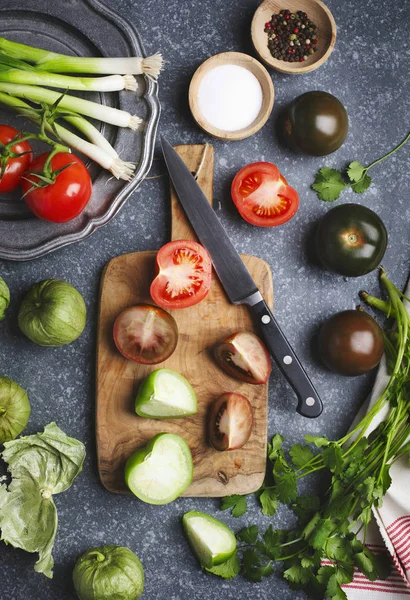 Chopped tomatoes and knife on cutting board, fresh vegetables on — Stock Photo, Image