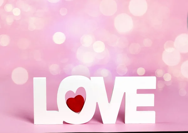 Palavra de amor no fundo cor-de-rosa com bokeh — Fotografia de Stock