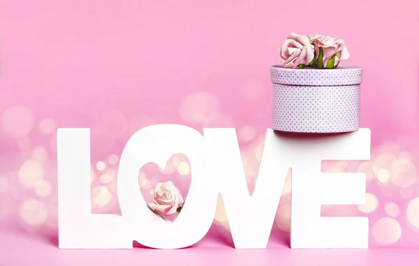 Word Love and gift box at pink color background — Stock Photo, Image