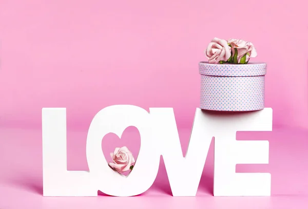 Λέξη Αγάπη και κουτί δώρου σε ροζ φόντο χρώμα — Φωτογραφία Αρχείου