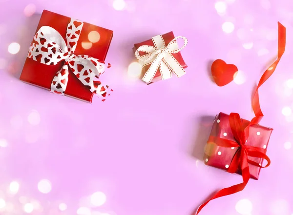 Ünnepi ajándék. Piros ajándékdobozok rózsaszínű háttérrel. Valentin-nap — Stock Fotó