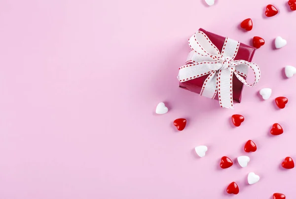 Valentin napi háttér. Piros ajándék doboz és cukorka rózsaszín hátizsák — Stock Fotó