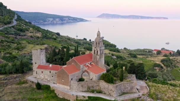 Igreja com telhado vermelho em um litoral na Dalmácia ao nascer do sol no verão . — Vídeo de Stock