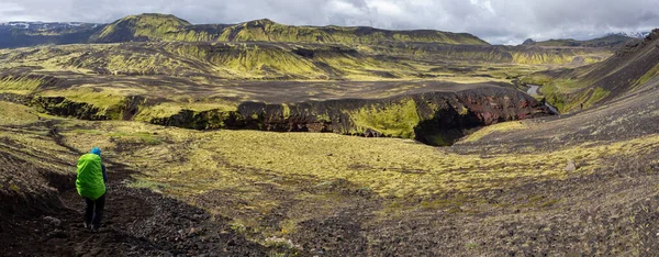 Woman traveler with backpak walking on the Laugavegur trail in Iceland, Europe.