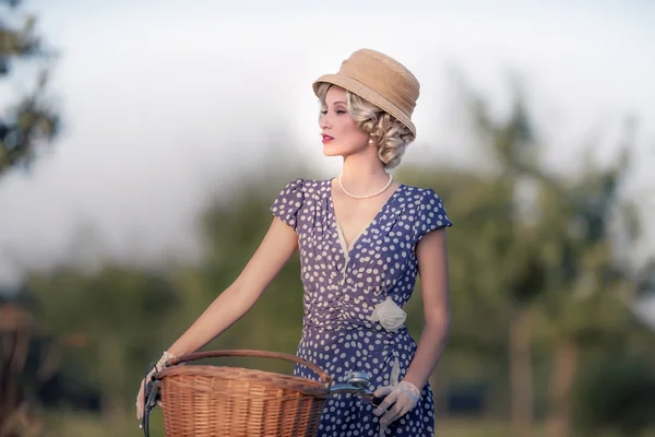 Blonde Frau mit Fahrrad in ländlicher Landschaft — Stockfoto