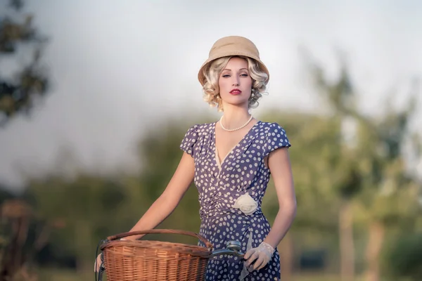 Blonde woman with bicycle in rural landscape — Stock Photo, Image