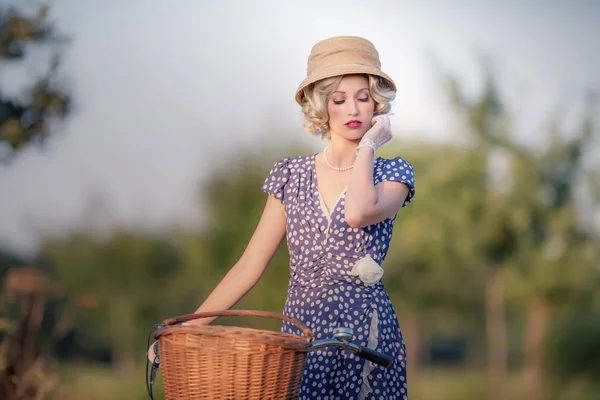 Blonde Frau mit Fahrrad in ländlicher Landschaft — Stockfoto
