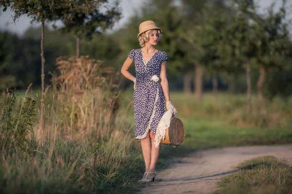 Mulher loira com bolsa na estrada rural — Fotografia de Stock