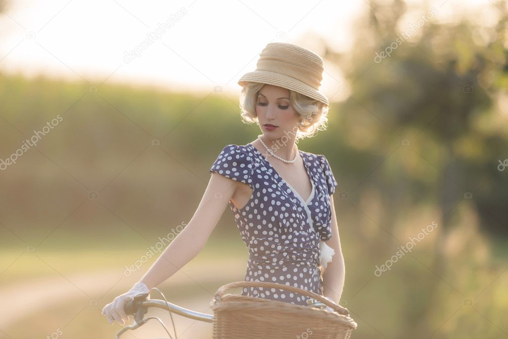 Blonde woman with bicycle in rural landscape
