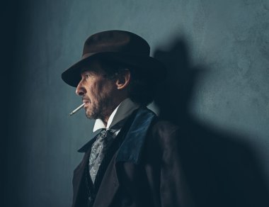 Sakallı adam sigara içiyor.