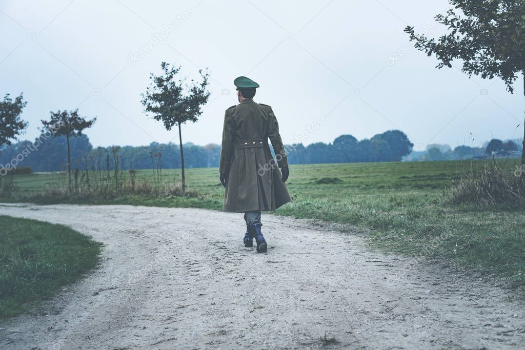 Military officer walking on rural road