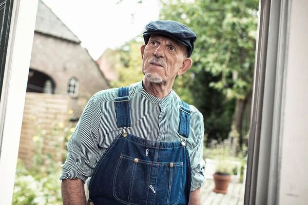 Vintage senior farmer wearing dungarees — Stock Photo, Image