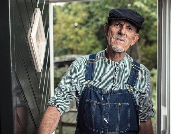 Ročník senior farmář nosí montérky — Stock fotografie