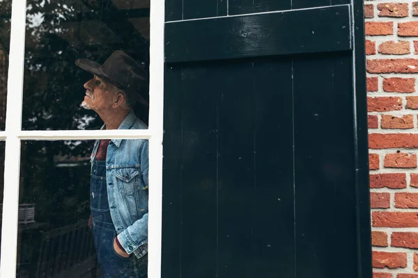 Landwirt schaut aus dem Fenster — Stockfoto