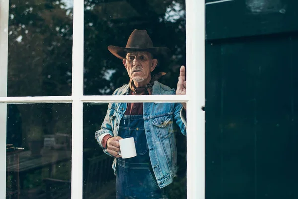 Farmer holding cup of coffee — Stock Photo, Image