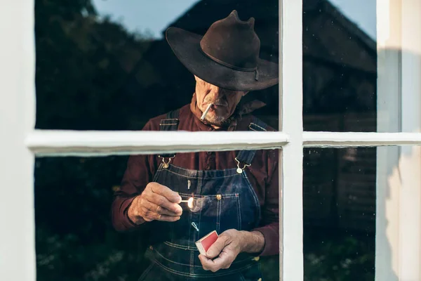 Senior man lighting cigarette — Stock Photo, Image