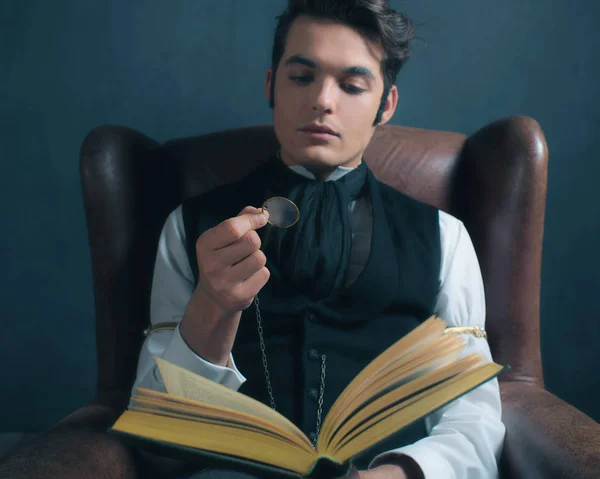 Людина читання книги з збільшувальним склом — стокове фото