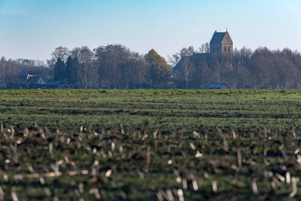 Farmland in winter with ancient church tower — Stock Photo, Image