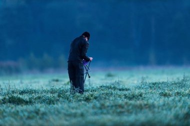 Uzun yürüyüşe çıkan kimse unfolding dışkı ıslak çayırda