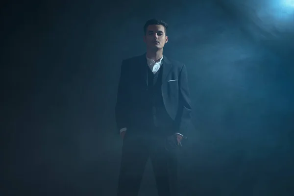 Gangster wearing suit standing in smoke. — Stock Photo, Image