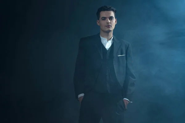 Γκάνγκστερ, φορώντας κοστούμι στέκεται στον καπνό. — Φωτογραφία Αρχείου