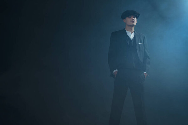 Гангстер в плоской кепке в дымовой комнате
. 