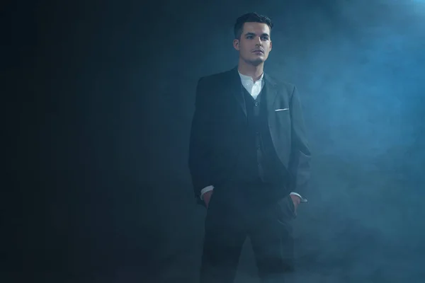 Gangster wearing suit standing in smoke. — Stock Photo, Image