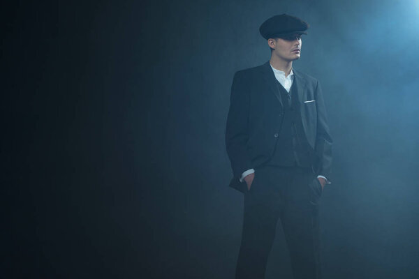 Гангстер в плоской кепке в дымовой комнате
. 