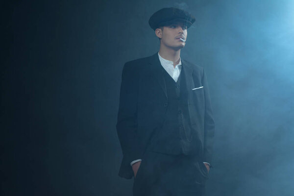 Гангстер в плоской кепке в дымовой комнате
. 