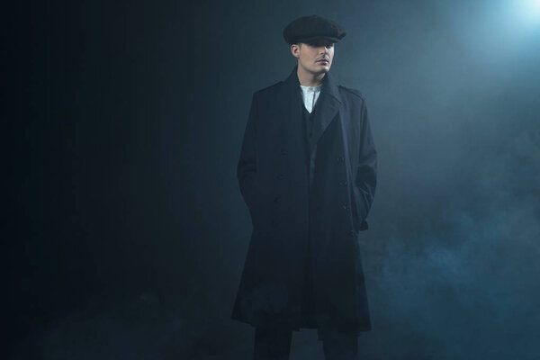 Гангстер в плоской кепке в дымовой комнате
. 