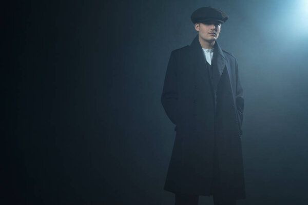 Гангстер в плоской кепке в дымовой комнате
. 