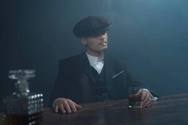 Gangster zittend aan tafel met whiskey. — Stockfoto
