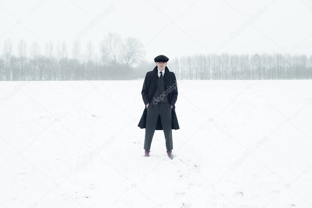 Gangster standing in winter snow landscape.  