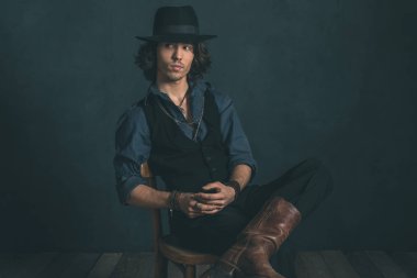 Sandalyede oturan şapkalı adam