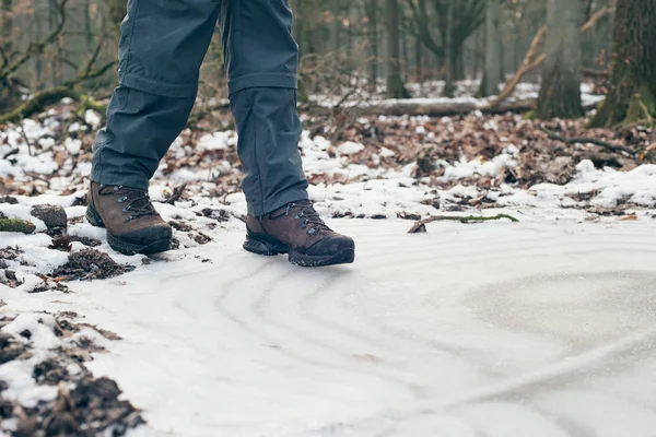 Shoes of hiker standing on frozen puddle — Stock Photo, Image
