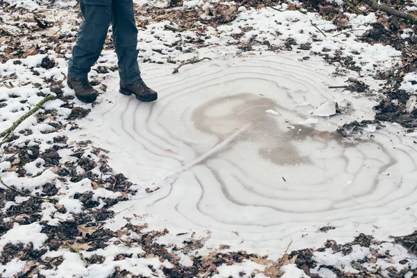 凍った水たまりの上に立ってハイカーの靴 — ストック写真