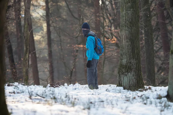 Jonge man staande in winter forest — Stockfoto