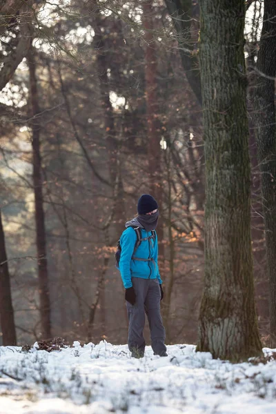Young man standing in winter forest — Stock Photo, Image