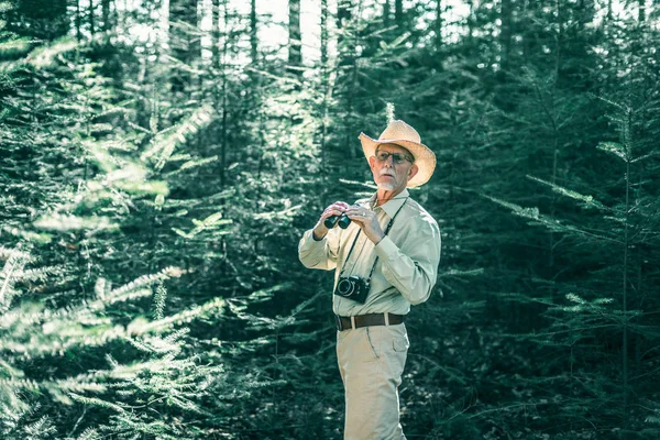 Homme retraité avec chapeau et jumelles — Photo